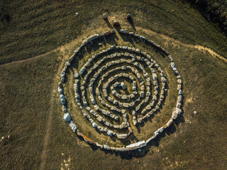 Spiral labyrinth made of stones, top view from drone