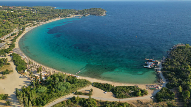 Aerial drone view of iconic sandy turquoise organised with sun beds and umbrellas beach of Paliouri in Kassandra Peninsula, Halkidiki, North Greece
