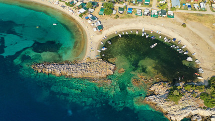 Fototapeta na wymiar Aerial drone view of iconic sandy turquoise organised with sun beds and umbrellas beach of Paliouri in Kassandra Peninsula, Halkidiki, North Greece