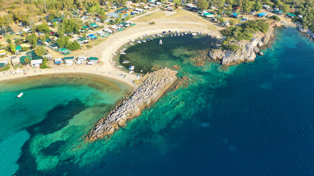 Aerial drone view of iconic sandy turquoise organised with sun beds and umbrellas beach of Paliouri in Kassandra Peninsula, Halkidiki, North Greece