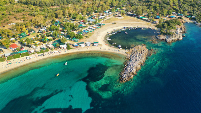Aerial drone view of iconic sandy turquoise organised with sun beds and umbrellas beach of Paliouri in Kassandra Peninsula, Halkidiki, North Greece