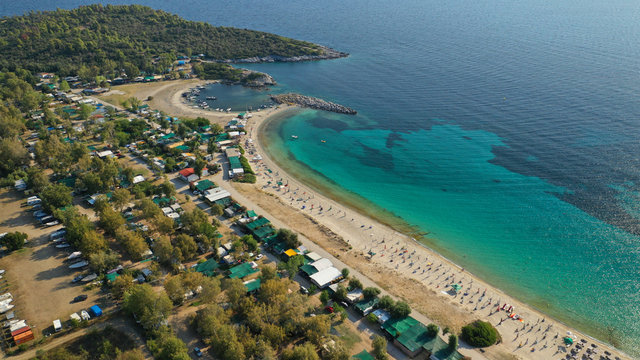 Aerial drone view of iconic sandy turquoise organised with sun beds and umbrellas beach of Paliouri in Kassandra Peninsula, Halkidiki, North Greece