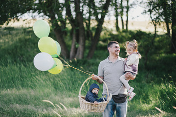 Happy father and his kids having fun in a green park.