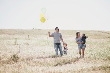 Happy family having fun on sunny meadow.
