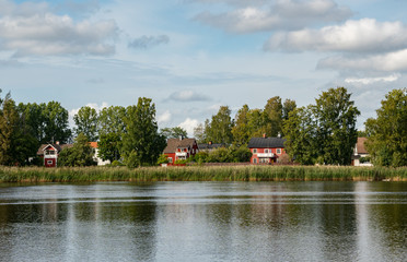 idyllic view in Karlstad Sweden. traditional houses next to the river sourrounded by the green nature