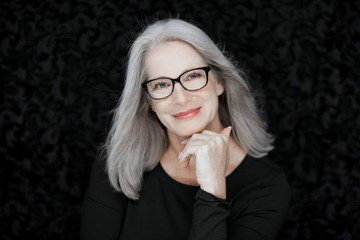 stunning beautiful and self confident best aged woman with grey hair smiling into camera