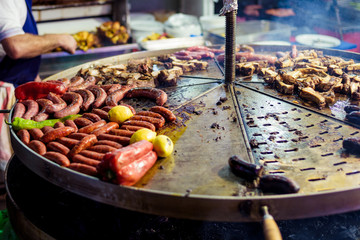 Assortment of marinated meat grilling over the hot coals on a BBQ with sausage, steak, chicken, spare ribs and kebabs. cooking concept.