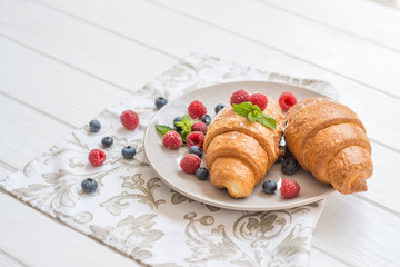 croissants with raspberries and blueberries with coffee