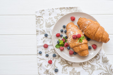 croissants with raspberries and blueberries with coffee