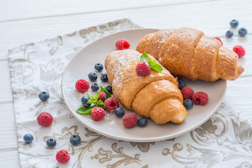 croissants with raspberries and blueberries with coffee