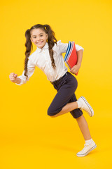 Fototapeta na wymiar Back to school. Kid cheerful schoolgirl running. Pupil want study. Active child in motion. Beginning school lesson. Keep going. Active kid. Hurry up. Girl with books on way to school. Knowledge day