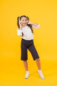 Home schooling. Small girl pupil headphones. Child happy listen music. Sing song. Audio book. Education and fun concept. Online schooling. Listening lesson. Child enjoy music sound. Audio schooling