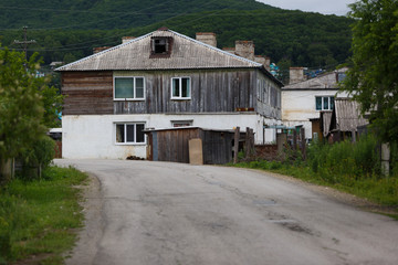 Fototapeta na wymiar The street of a large village with wooden houses and a dusty road. Real Russia