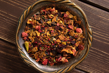 Lot of pieces of lavender strawberry ice tea in old iron bowl flatlay on brown wood