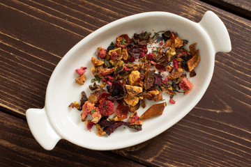 Lot of pieces of lavender strawberry ice tea in ceramic stewpan flatlay on brown wood