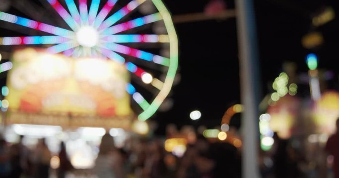 Carnival fair grounds at night. Defocused footage. Shot in 4K RAW on a cinema camera.