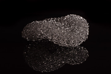 One whole cleaning kitchen sponge isolated on black glass
