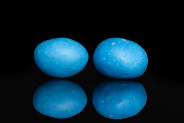 Group of two whole blue sugared nut dragee isolated on black glass