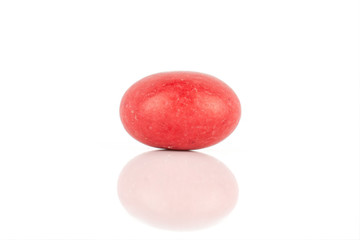 One whole red sugared nut dragee isolated on white background