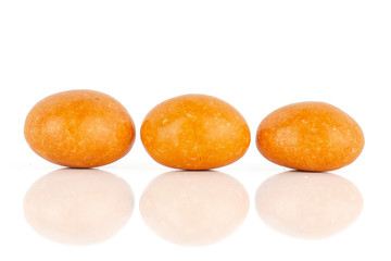 Group of three whole orange sugared nut dragee isolated on white background