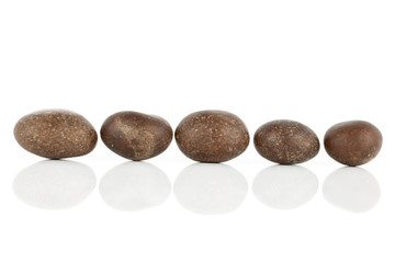 Fototapeta na wymiar Group of five whole brown sugared nut dragee isolated on white background