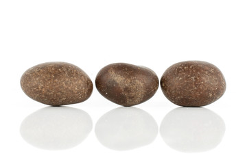 Fototapeta na wymiar Group of three whole brown sugared nut dragee isolated on white background