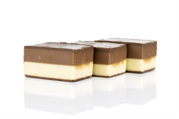 Group of three whole sweet mellow two coloured nougat piece in row isolated on white background