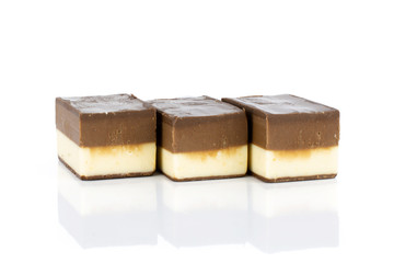 Group of three whole mellow two coloured nougat piece in row isolated on white background