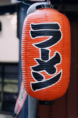 Close-up of Japanese red paper lantern at a Ramen restaurant, the text in black says "Ramen" in Japanese. © DK Photography