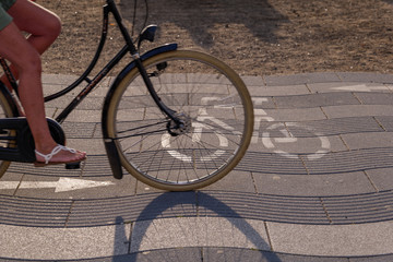 Close up view of bicycle lane symbol and cyclist ride bicycle on promenade riverside of Rhein River in Düsseldorf, Germany. Cycling friendly city in europe. Eco friendly mobility transportation. © Peeradontax