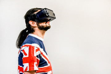 Man on white background with Virtual Reality headsets on, experimenting and testing new VR technology. Man with 4K Glasses watching games or videos.