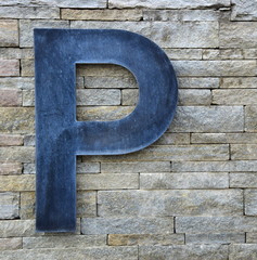 Modernes Parkplatzschild auf einer Steinmauer