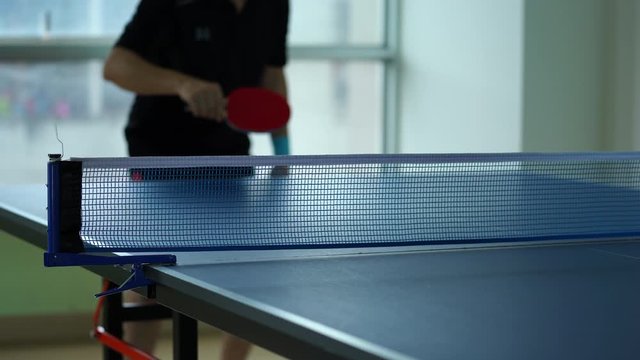 Ping pong table, Male playing table tennis with racket and ball in a sport hall