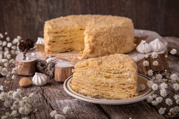 Round multi-layered cake Napoleon with custard, on a  wooden table background. Selective focus