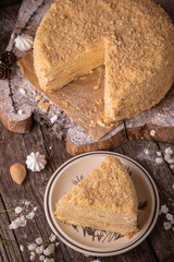 Round multi-layered cake Napoleon with custard, on a  wooden table background. Selective focus