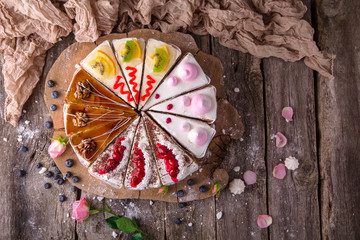 Assorted cake from pieces of different cakes. Shocolate, biscuit, caramel, cherry, berry, soufflé