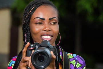 young woman with camera, smiling.