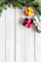 Frame from gifts in boxes and spruce for new year eve on white wooden background top veiw mockup