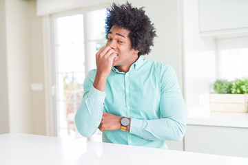 African American business man wearing elegant shirt looking stressed and nervous with hands on mouth biting nails. Anxiety problem.