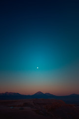 Mountains, volcano and moon in the desert
