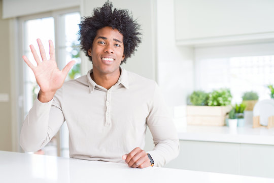 African American man at home showing and pointing up with fingers number five while smiling confident and happy.