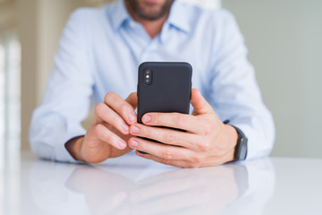 Close up of man hands using smartphone and smiling