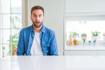 Handsome man at home afraid and shocked with surprise expression, fear and excited face.