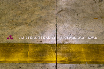 Radiologically Controlled Area warning sign on cracked and grunge concrete floor