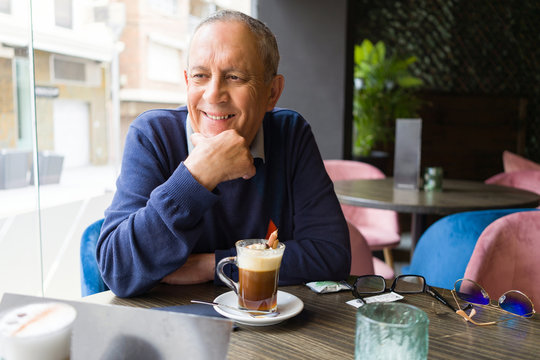 Handsome middle age senior man drinking coffee at restaurante, smiling happy enjoying and relaxing retirement