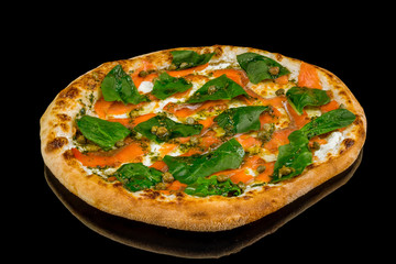 Pizza with salmon and Philadelphia cheese and spinach on black glass with reflection