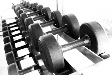 dumbbell in gym - vintage effect and sun flare filter effect