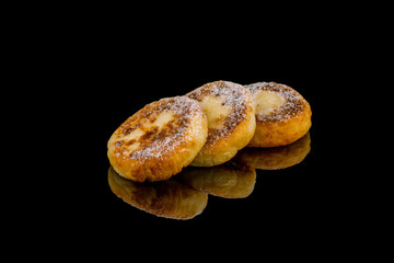 cheesecakes from cottage cheese on black glass with reflection