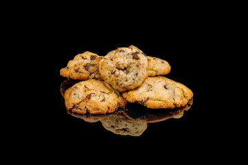 cookies with chocolate drops on black glass with reflection