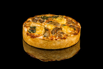 quiche with mushrooms on black glass with reflection